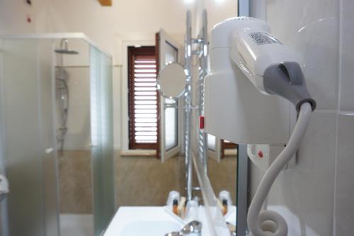 a white hair dryer in a bathroom with a sink at San Pietro in Mileto