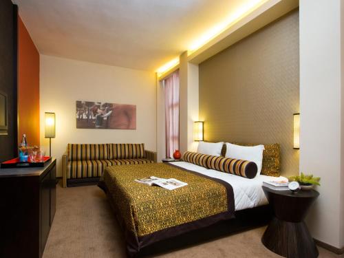 a hotel room with a bed and a couch at Dan Boutique Hotel Jerusalem in Jerusalem