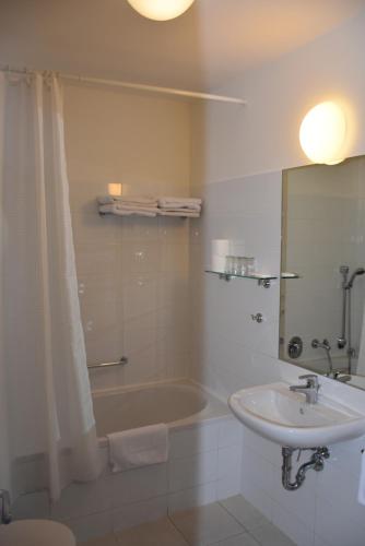 y baño con lavamanos, bañera y lavamanos. en Aparthotel Austria Suites, en Praga