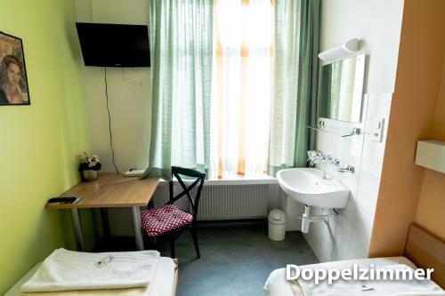 a bathroom with a desk and a sink and a window at Hotel & Backpackers Zak Schaffhausen in Schaffhausen