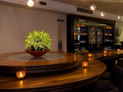 a bar with a bowl of flowers on a wooden table at Dan Boutique Hotel Jerusalem in Jerusalem