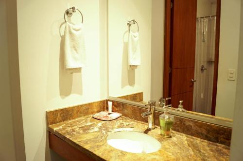 W łazience znajduje się umywalka i lustro. w obiekcie Hotel Factory Green Bogotá w mieście Bogota