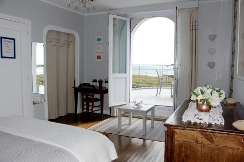 1 dormitorio con cama y vistas al océano en Villa Keris - Face Océan, en Audierne
