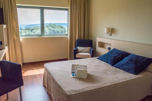 a hotel room with a bed and a window at Hotel Les Torres in Martorell
