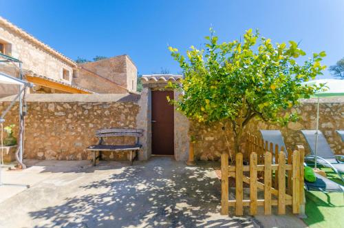 a house with a wooden gate and a tree at Finca Can Maria Costitx in Costitx