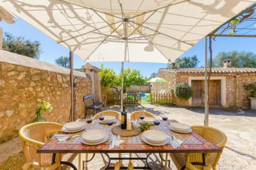a table under an umbrella on a patio at Finca Can Maria Costitx in Costitx