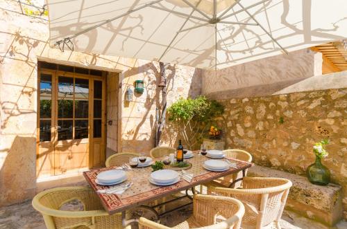 a table with chairs and an umbrella on a patio at Finca Can Maria Costitx in Costitx
