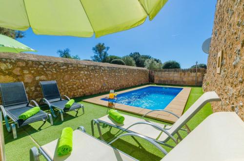 a swimming pool with chairs and an umbrella at Finca Can Maria Costitx in Costitx