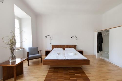 a bedroom with a bed and a chair at Julija&Robert's Riverview Apartments and Rooms in Ljubljana