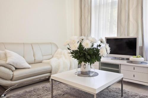 a living room with a couch and a table with flowers at Hotel Dom Aktera in Odesa