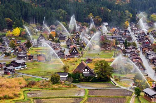 a small village with water spraying in the air at Shirakawago Guest House Kei in Shirakawa