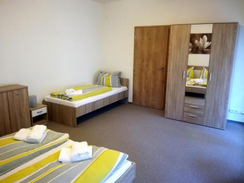 a room with two beds and a closet with two beds at Penzion Dominik in Železná Ruda