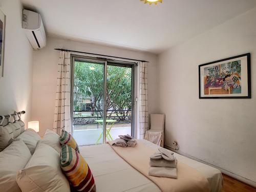 une chambre avec un grand lit blanc et une fenêtre dans l'établissement Nestor&Jeeves - MARIN DEBUSSY - Central - By shopping area, à Nice