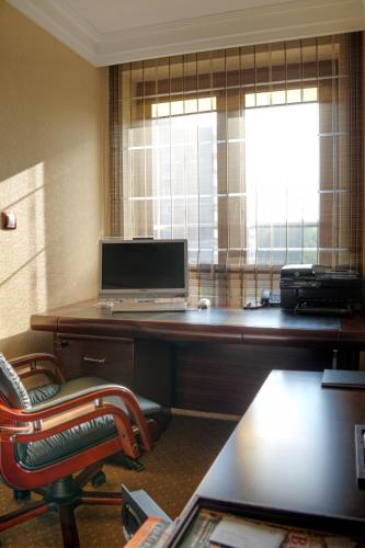 an office with a desk with a laptop and a chair at M Hotel Sosnowiec in Sosnowiec