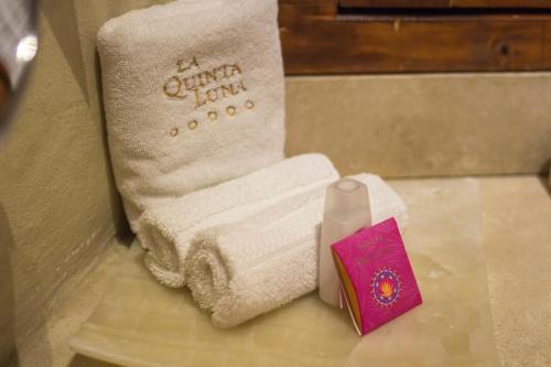 a bathroom with two towels and a book on a counter at Quinta Luna in Cholula