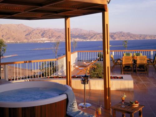 a hot tub on a deck with a view of the ocean at Dan Eilat Hotel in Eilat