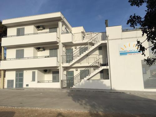a white building with stairs in front of it at MareinSicilia: Talia Residence in Sampieri