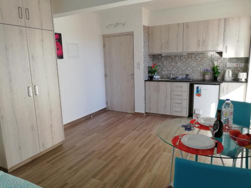 a kitchen with a table and a kitchen with a refrigerator at Chicos Studios in Ayia Napa