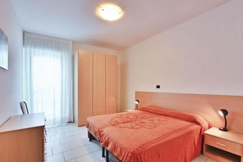 リニャーノ・サッビアドーロにあるCondominio Croce del Sudのベッドルーム1室(赤いベッドカバー付)