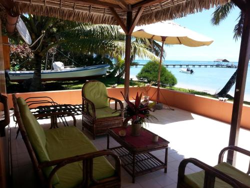 a balcony with chairs and an umbrella and the ocean at Villa Alexandra in Sainte Marie