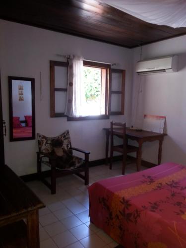 a bedroom with a bed and a table and a window at Villa Alexandra in Sainte Marie