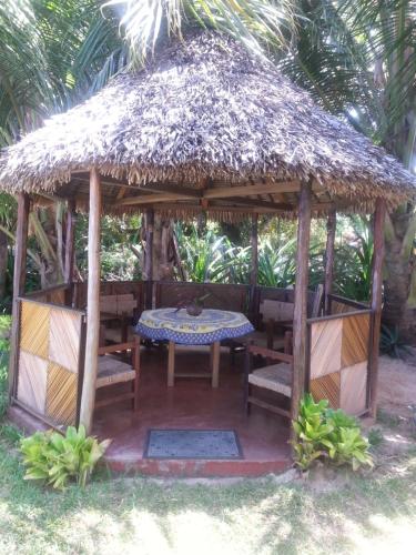 a wooden gazebo with a table and chairs at Villa Alexandra in Sainte Marie