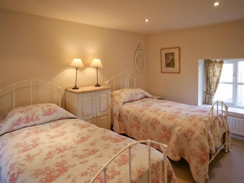 A bed or beds in a room at Manor Cottage 