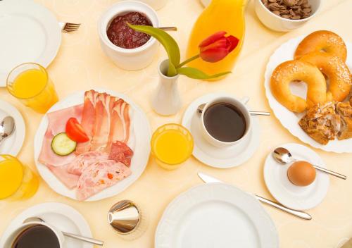 a table with plates of food and cups of coffee and pretzels at Hotel Brunnwirt in Weissbriach