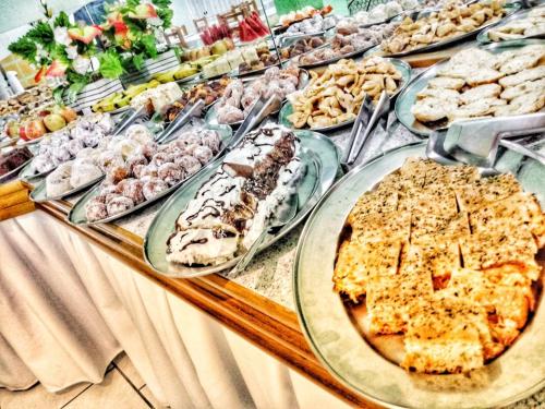 una mesa llena de diferentes tipos de comida en platos en Hotel Maichel, en Erval Velho