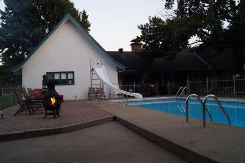 a backyard with a pool and a slide next to a house at B&B Aux Deux Pignons in Donnacona