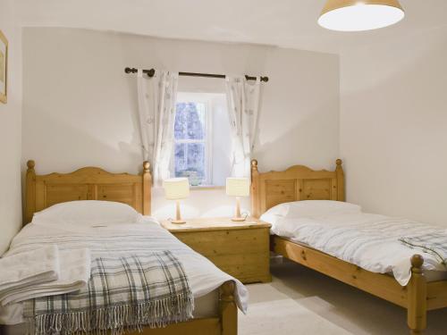 A bed or beds in a room at Brook Cottage 