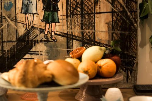 a plate of fruit on a table with a painting at Casuzza di Girgenti con vista Valle dei Templi! in Agrigento