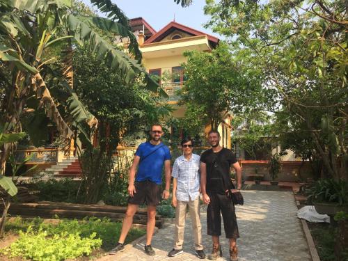 three men standing in front of a house at Hoang Giang Homestay in Ninh Binh