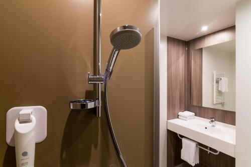 a bathroom with a shower with a toilet and a sink at ibis Styles Haarlem City in Haarlem