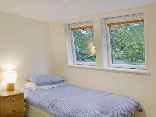 A bed or beds in a room at Millnain Cottage 
