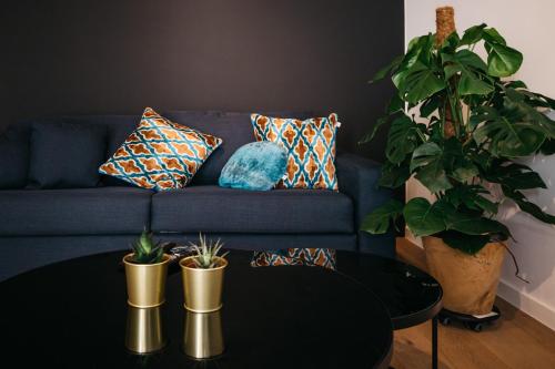 a blue couch with pillows and a table in a living room at Charlie's Bed & Breakfast in Antwerp