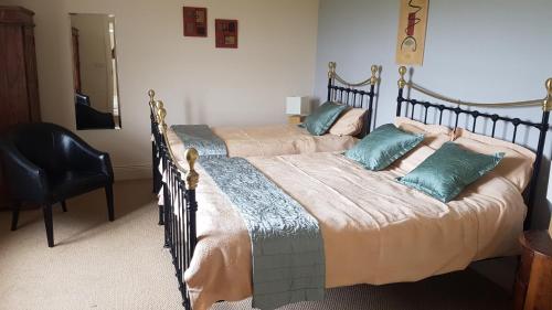 a bedroom with two beds and a chair at 7 Doolin Court in Doolin