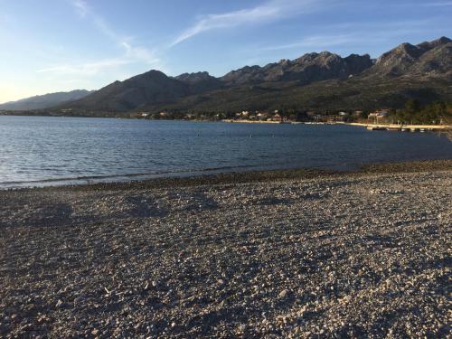 a rocky beach with mountains in the background at Apartment Ante and Dijana in Starigrad-Paklenica