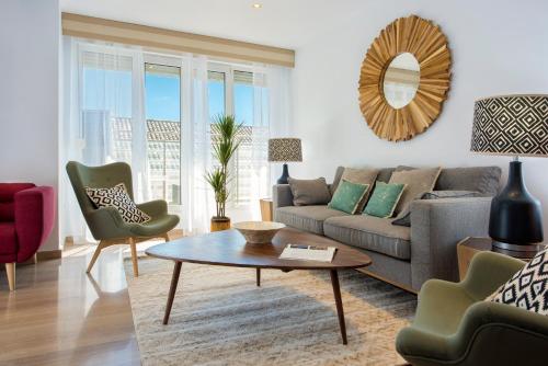 a living room with a couch and a table and chairs at Genteel Home Isabel la Católica in Granada