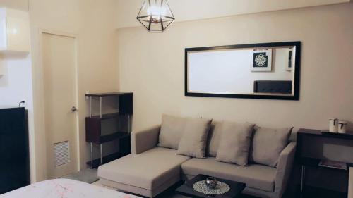 un soggiorno con divano e specchio di Palm Tree Villas 1 a Manila