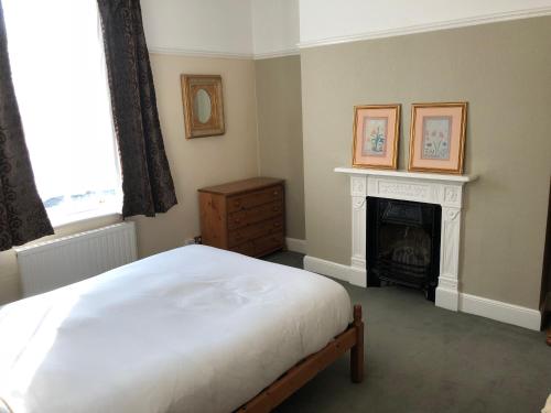 a bedroom with a white bed and a fireplace at Seventeen Latham in Preston