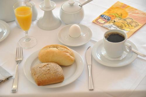 a table with a plate of bread and a cup of coffee at Hotel Ambiente in Halberstadt