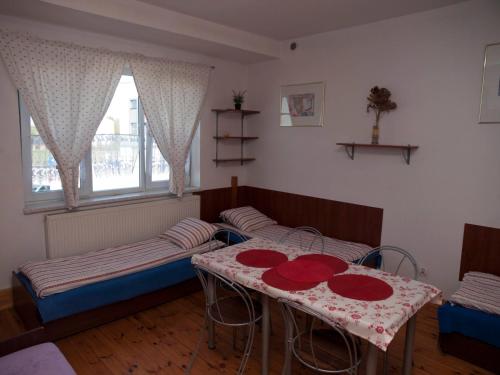 a room with two beds and a table in it at Pokoje Gościnne "Amelia" in Raszyn
