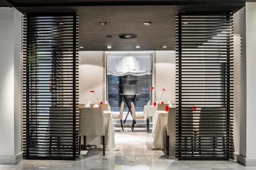 a dining room with tables and a large window at Hospes Amérigo, Alicante, a Member of Design Hotels in Alicante