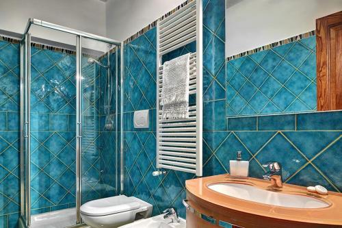 een blauw betegelde badkamer met een toilet en een wastafel bij Elena Apartment in Piano di Sorrento