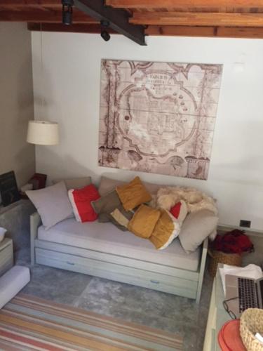 un sofá con almohadas en una habitación en Las Glicinas Boutique Apartments en Colonia del Sacramento