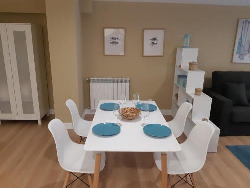 a dining room with a white table and white chairs at Apartamentos Nájera in Nájera