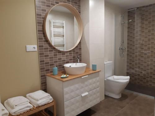 a bathroom with a sink and a toilet and a mirror at Apartamentos Nájera in Nájera