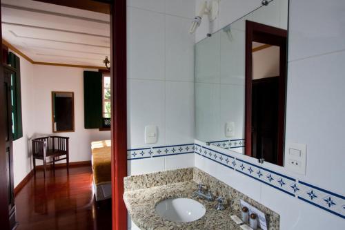 een badkamer met een wastafel en een spiegel bij Pousada Do Ouvidor in Ouro Preto
