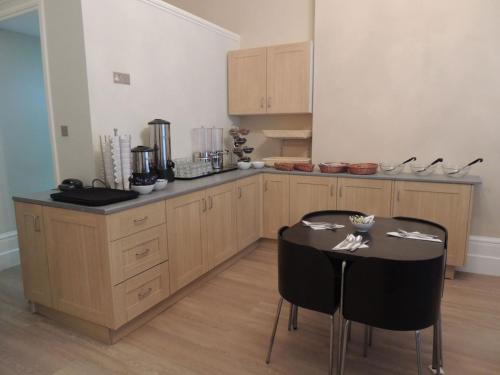 a kitchen with a table and two chairs in it at Hyde Park Boutique Hotel in London